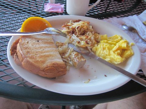 1991 Ford LTD Crown Victoria - A hearty breakfast is served on a metal-grate table, complete with toast, eggs, and hash browns.