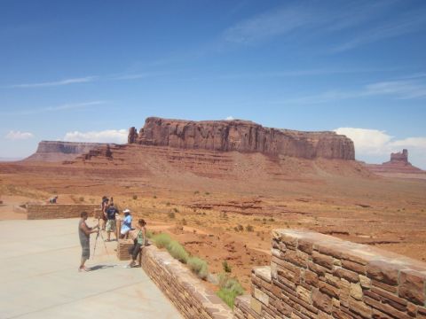 1991 Ford LTD Crown Victoria - Tourists observe the iconic buttes of Monument Valley under a clear blue sky.