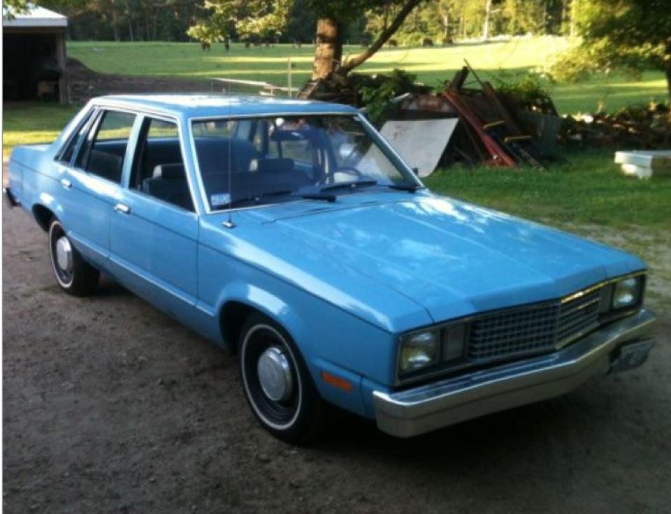 Blue sedan, 3/4 front view. Likely a 1978 Ford Fairmont
