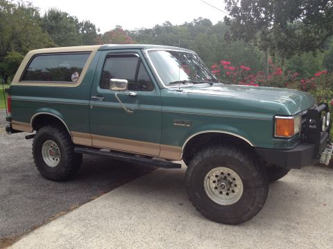 1989 Ford Bronco - This 1989 Ford Bronco features a two-tone green and tan paint scheme with aftermarket wheels and tires.