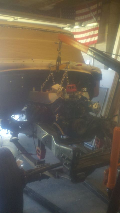 1967 Ford F-250 - The engine and chassis of a truck are visible as the engine is being installed.