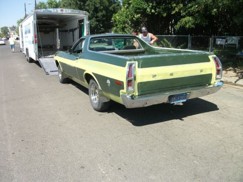 1972 Ford Ranchero - A two-tone green and yellow 1972 Ford Ranchero is parked on a street with a trailer behind it.