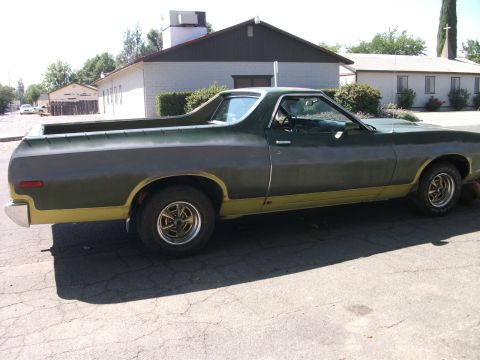 1972 Ford Ranchero - A 1972 Ford Ranchero is parked on a paved surface in front of buildings.