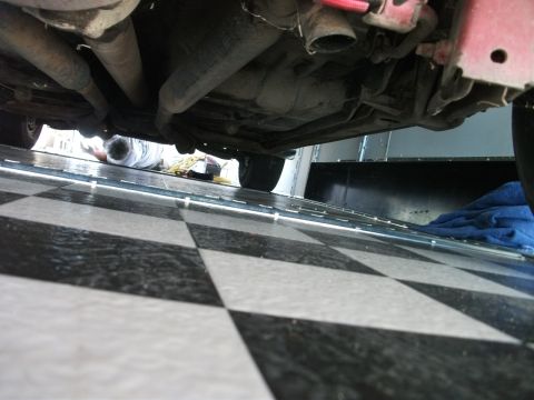 1972 Ford Ranchero - Undercarriage view of a vehicle with exhaust pipes and a person lying underneath.