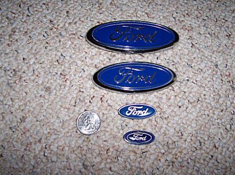 2003 Ford Expedition - Several Ford emblems of varying sizes are laid out on a carpeted surface.