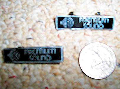 2003 Ford Expedition - Two "Premium Sound" emblems are shown next to a U.S. quarter for scale.