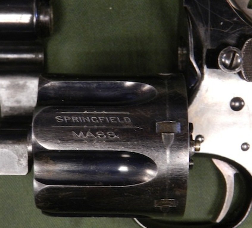 Revolver cylinder with "SPRINGFIELD MASS." engraved, showing part of the frame and trigger