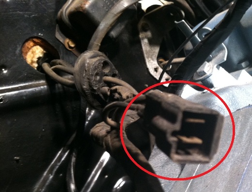Close-up of a dirty electrical connector with wires, circled in red