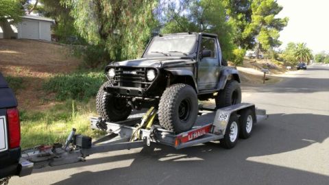 1987 Suzuki Samurai - A modified 1987 Suzuki Samurai is loaded onto a U-Haul trailer for transport.