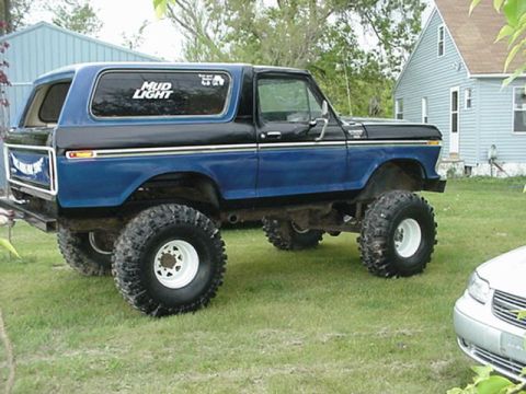 1979 Ford Bronco - Modified Ford Bronco with off-road tires and a Mud Light sticker on the window.