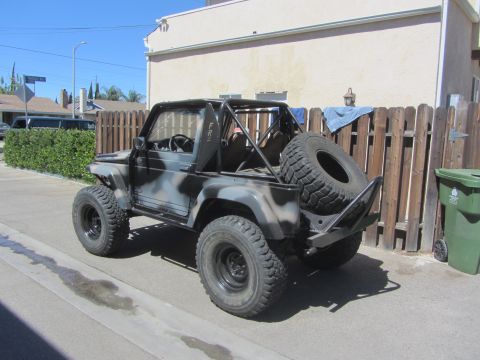 1987 Suzuki Samurai - This modified Suzuki Samurai is parked on a residential street.