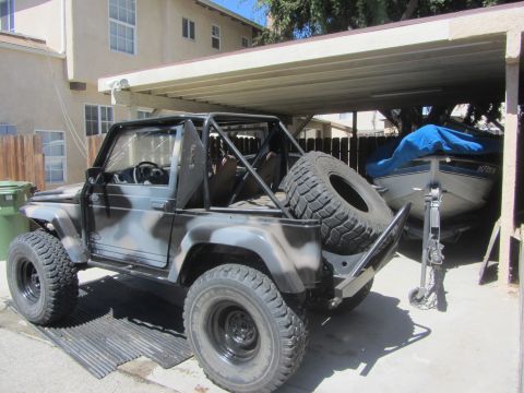 1987 Suzuki Samurai - Suzuki Samurai parked under a carport with a boat in the background.