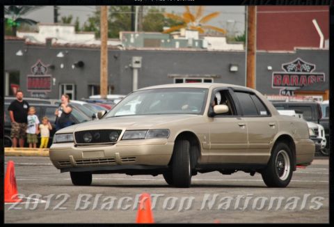 2000 Mercury Grand Marquis - Tan 2000 Mercury Grand Marquis navigates a course marked by orange cones.