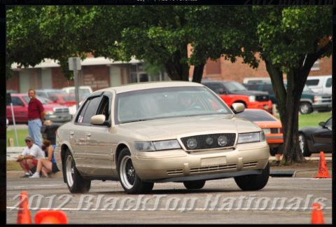 2000 Mercury Grand Marquis - A gold 2000 Mercury Grand Marquis sedan is seen from the front-three-quarter angle during an event.