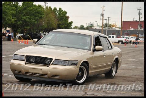 2000 Mercury Grand Marquis - Tan 2000 Mercury Grand Marquis sedan seen from a 3/4 front angle during an event.