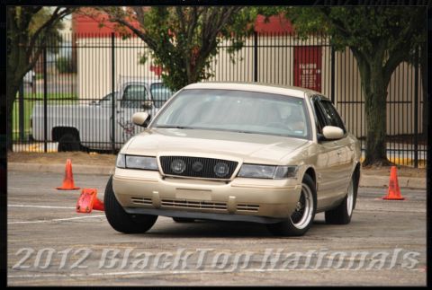 2000 Mercury Grand Marquis - Gold 2000 Mercury Grand Marquis navigates a course marked by orange cones.