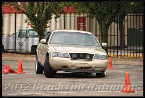 2000 Mercury Grand Marquis - A gold 2000 Mercury Grand Marquis navigates a course marked by traffic cones.