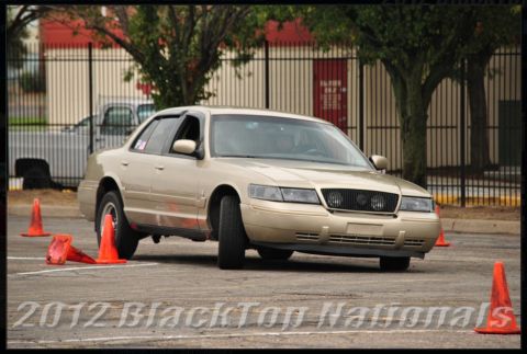 2000 Mercury Grand Marquis - A gold 2000 Mercury Grand Marquis navigates a course marked by orange cones.