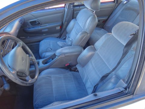 1993 Ford Taurus - The interior of a 1993 Ford Taurus, cloth seats and a gray dashboard.