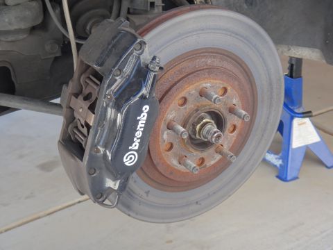 1993 Ford Taurus - A close-up view of a vehicle's brake system, a Brembo caliper and a rusty rotor.