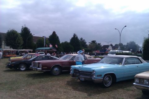 1991 Ford LTD Crown Victoria - A gathering of classic automobiles displayed outdoors on a cloudy day.