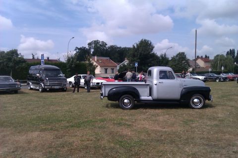 1991 Ford LTD Crown Victoria - A classic silver and black pickup truck is seen at an outdoor gathering with several other vehicles present.