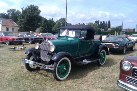 1991 Ford LTD Crown Victoria - A 1928 Ford Model A convertible is shown at an outdoor car show with other vehicles.