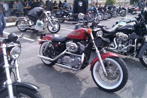 1991 Ford LTD Crown Victoria - A variety of motorcycles are parked together in an outdoor lot.