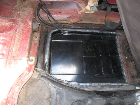 1970 Volkswagen Beetle - Customized floor pan with a black cover and visible wiring, suggesting interior modifications.