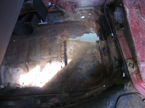 1970 Volkswagen Beetle - Interior floor pan shows significant rust damage and deterioration.