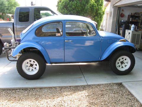 1970 Volkswagen Beetle - A modified blue Volkswagen Beetle sits parked in a driveway, next to a pickup truck.