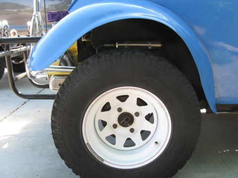 1970 Volkswagen Beetle - Close-up of a modified Volkswagen Beetle, likely a Baja Bug, showing its front wheel and suspension.