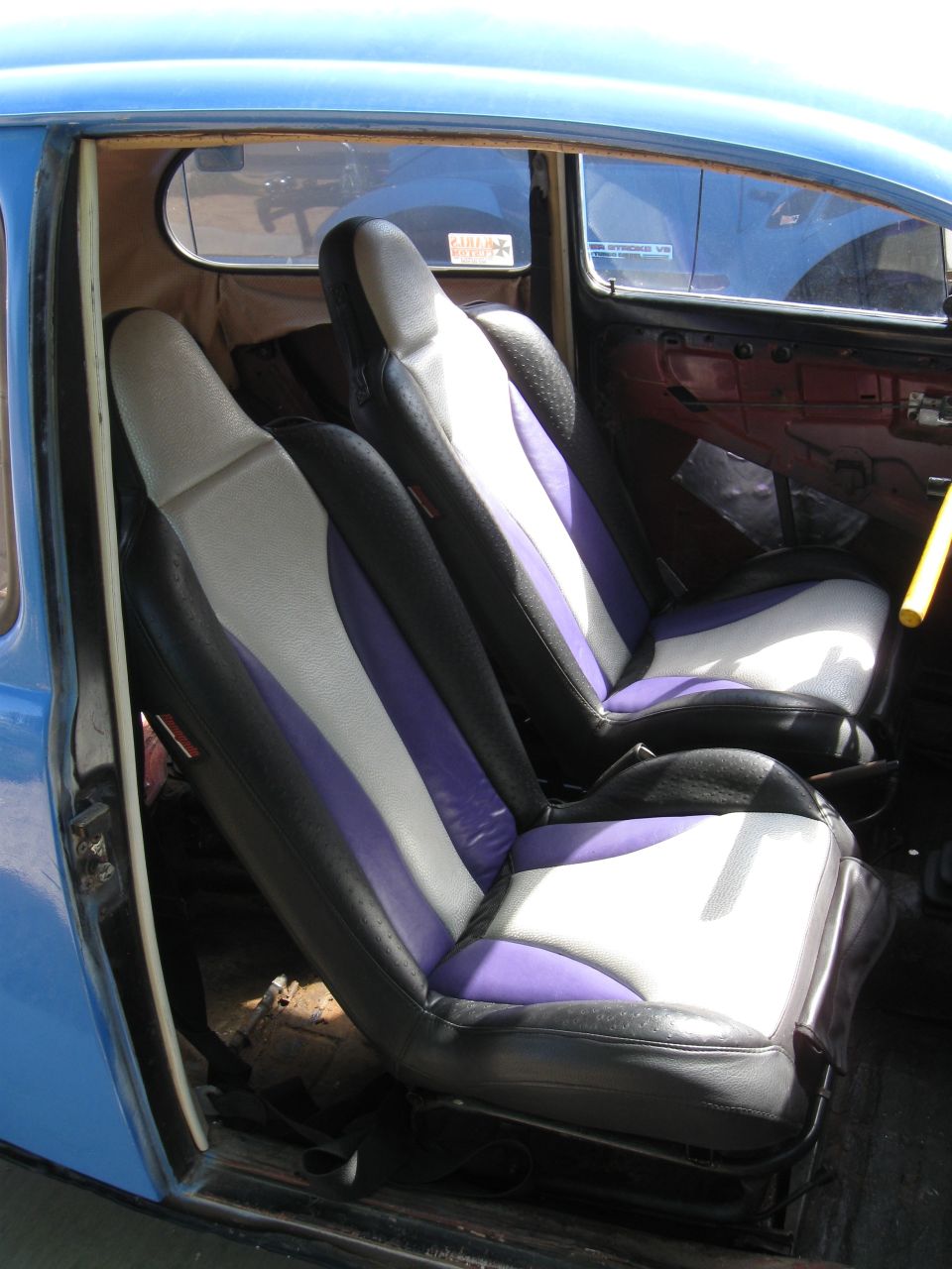 1970 Volkswagen Beetle interior showing custom black, white, and purple seats