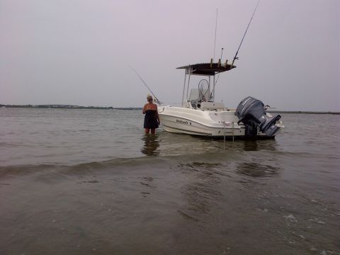 2007 Wellcraft 200 LT Fisherman - A person stands in the water next to a Wellcraft boat with a Yamaha outboard motor.