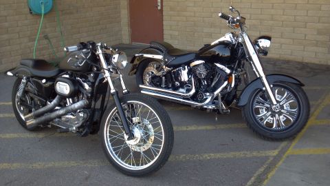 2002 Harley-Davidson XL Sportster - Two Harley-Davidson motorcycles are parked next to each other in front of a brick building.