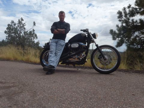 2002 Harley-Davidson XL Sportster - Man poses with his 2002 Harley-Davidson XL Sportster motorcycle on a roadside with dry grass and trees.