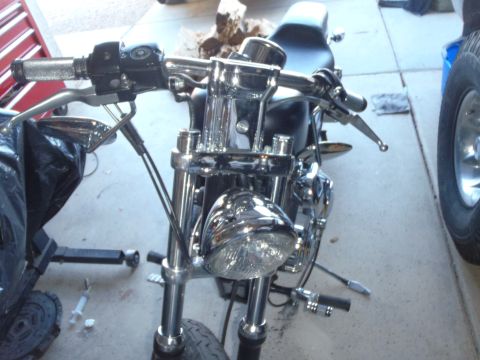 2002 Harley-Davidson XL Sportster - Close-up view of a motorcycle's front end, showing handlebars, headlight, and part of the seat.
