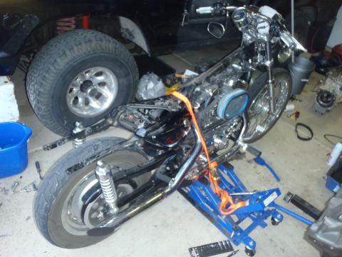 2002 Harley-Davidson XL Sportster - A 2002 Harley-Davidson XL Sportster motorcycle is shown on a lift in a workshop, undergoing repairs or modifications.