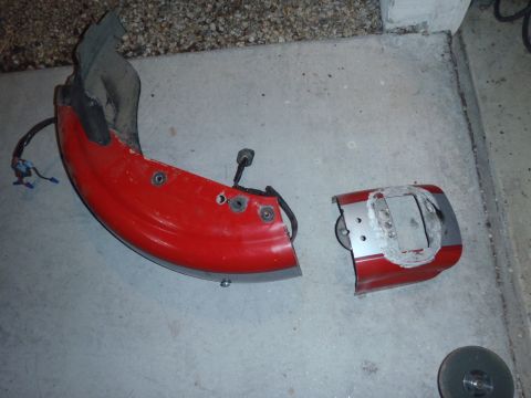 2002 Harley-Davidson XL Sportster - Two red motorcycle fender pieces, possibly from a Harley-Davidson, are shown on a concrete surface.