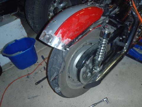 2002 Harley-Davidson XL Sportster - Close-up of a motorcycle's rear fender and wheel, with visible damage and repair work.