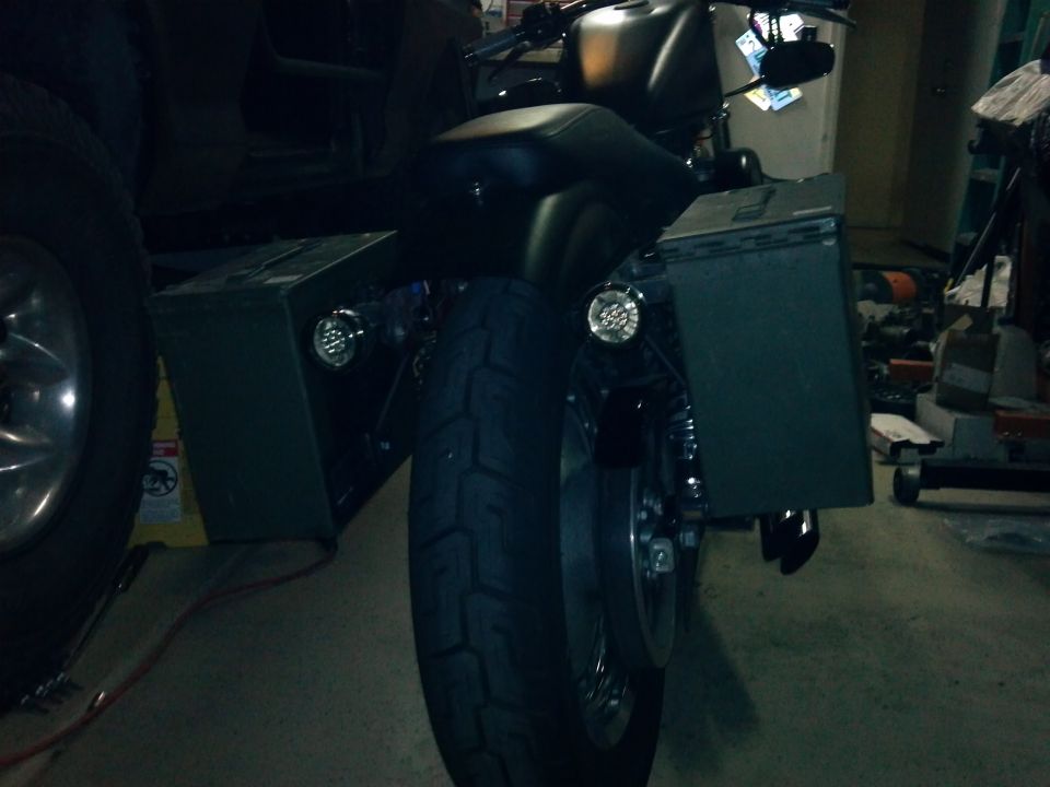 Rear view of black motorcycle with saddlebags and aftermarket lights