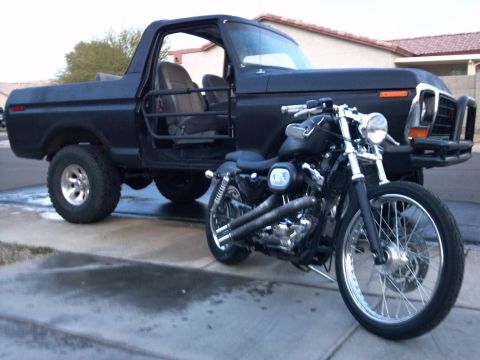 2002 Harley-Davidson XL Sportster - A black motorcycle is parked in front of a black pickup truck that has had its doors removed.