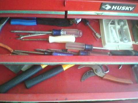 1996 Ford F-150 - A red tool drawer is filled with various hand tools, including screwdrivers, pliers, and pruning shears, with a Husky logo on the top.