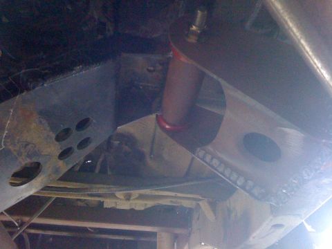 1987 Suzuki Samurai - The underside of a vehicle reveals its structural components and suspension system.