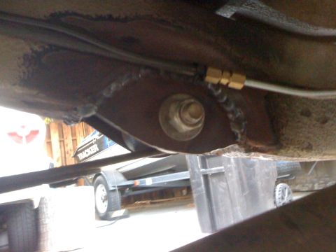1987 Suzuki Samurai - Close-up of vehicle undercarriage, with a boat trailer and the word 'TRACKER' visible in the background.