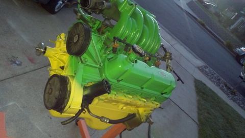 1987 Ford Bronco - This engine, painted in bright green and yellow, is displayed on an orange stand.
