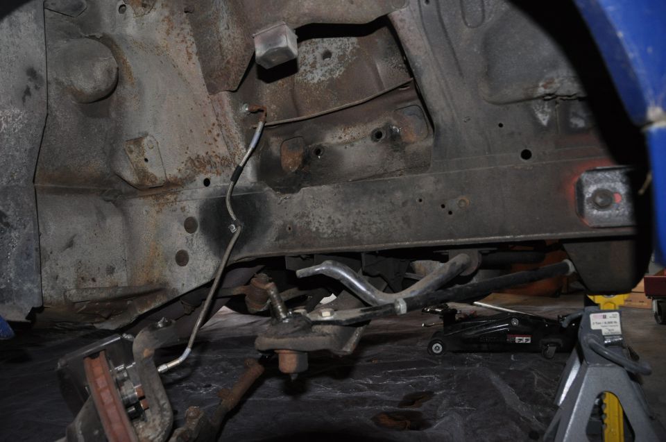 1971 Ford Mustang front suspension components on jack stands, showing rust and wear