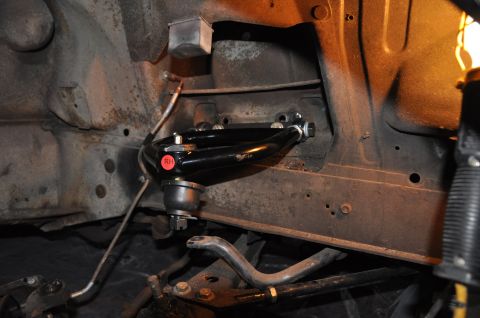 1971 Ford Mustang - A close-up view of a vehicle's front suspension, focusing on a newly installed black upper control arm.