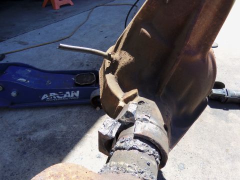 1968 Ford Bronco - Welding a differential housing with a floor jack nearby. The part appears to be heavily used.