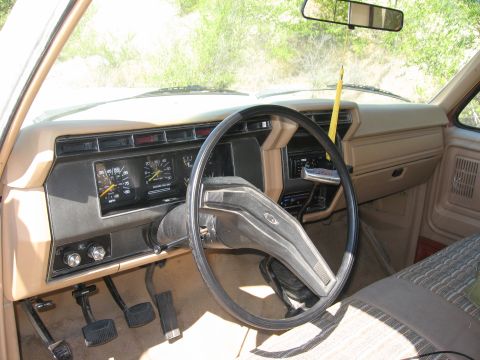 1981 Ford Bronco - Interior of a 1980s Ford truck, showing the dashboard, steering wheel, and pedals.